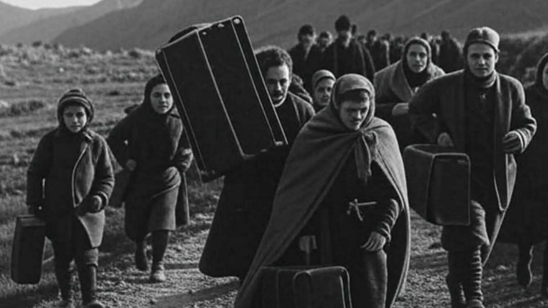 Jewish refugees crossing mountain terrain during WWII, representing escape routes over the Pyrenees
